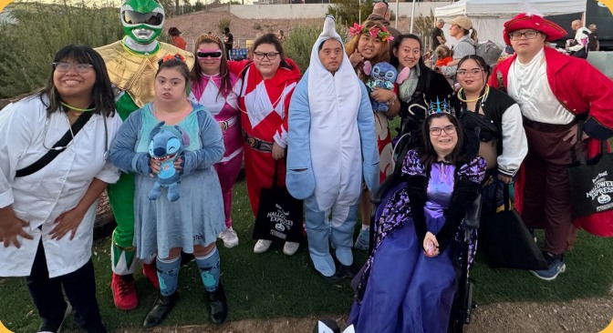 The group dressed up in Halloween costumes at an outdoor evening event.