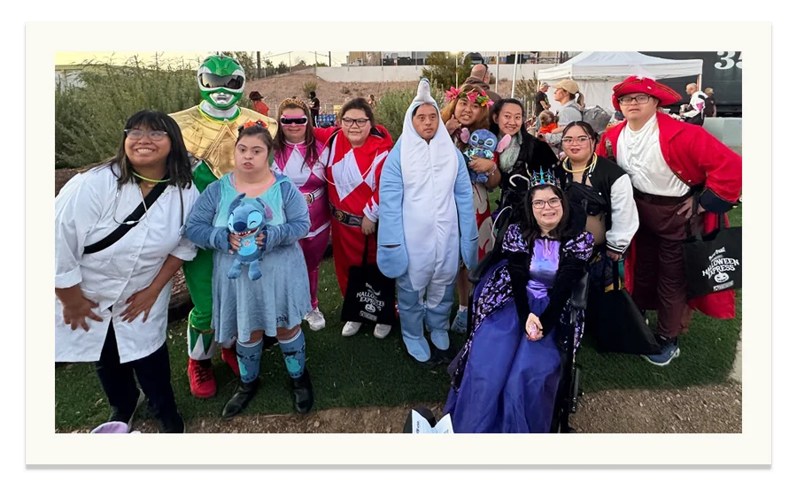 The group dressed up in Halloween costumes at an outdoor evening event.